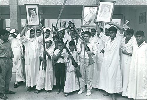 Гроздобер фотографија на мажи и деца протестираат додека држат пиштоли и рамки за слики на еден човек.