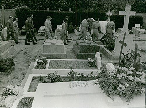 Гроздобер фотографија на луѓе кои носат ковчег во гробиштата.